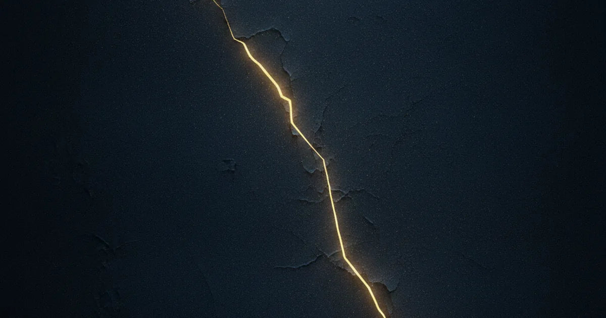 Fenditura dorata che attraversa una parete di pietra scura, luce che filtra da una crepa non del tutto sanata