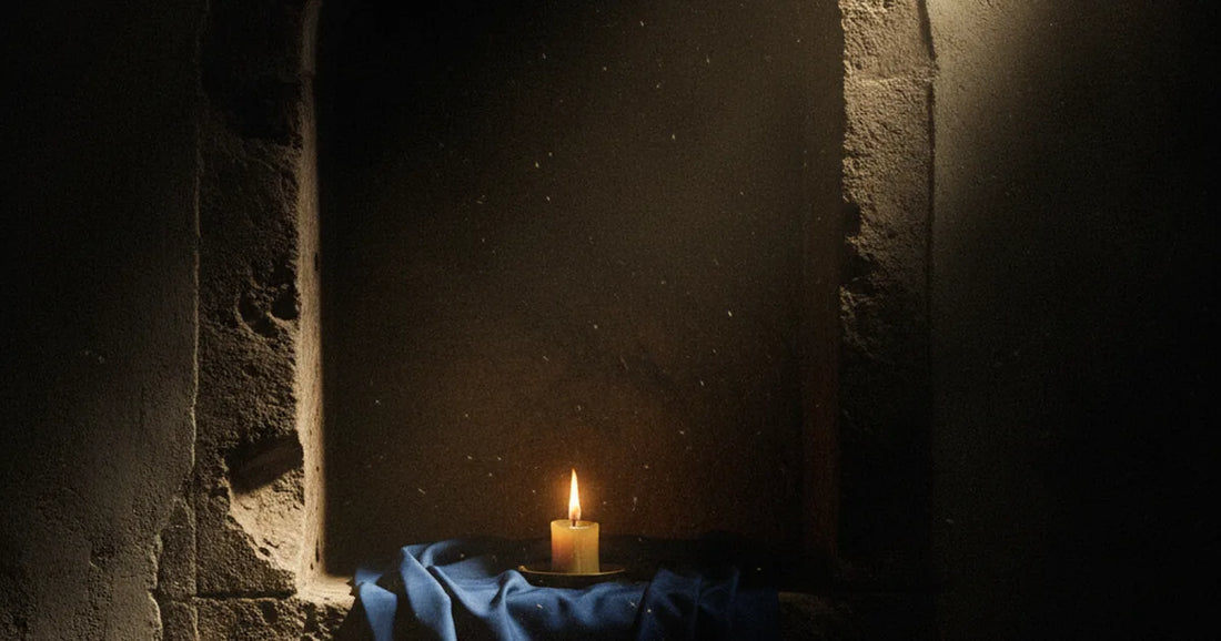 Nicchia di pietra con una candela votiva e un velo blu, evocando il culto mariano